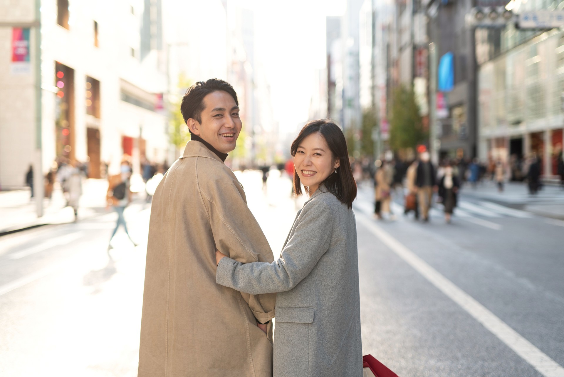 Smiling couple looking over shoulder on street